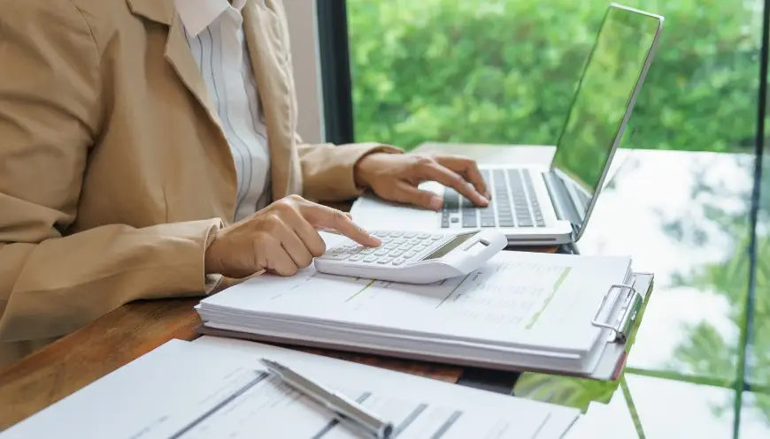 Employee reviewing ITAD budget data on a laptop in a corporate setting.