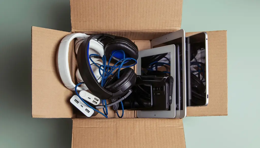 Electronics in a box for recycling during a spring cleaning session.|Electronics in a cardboard box for recycling.