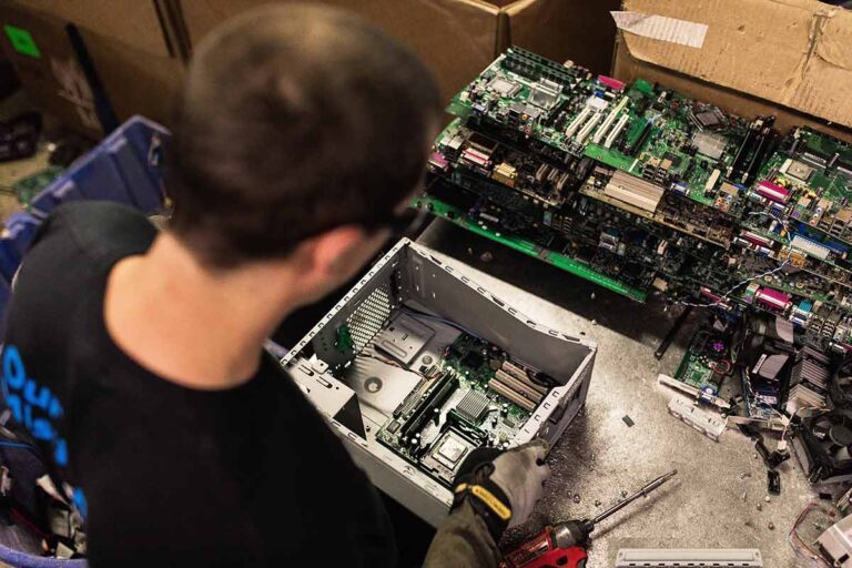 A Dynamic Lifecycle Innovations Technician disassembling a computer.