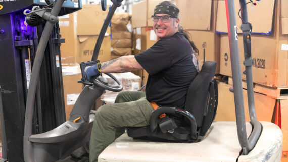 Dynamic Lifecycle Innovations employee operating a forklift in the materials recycling facility.