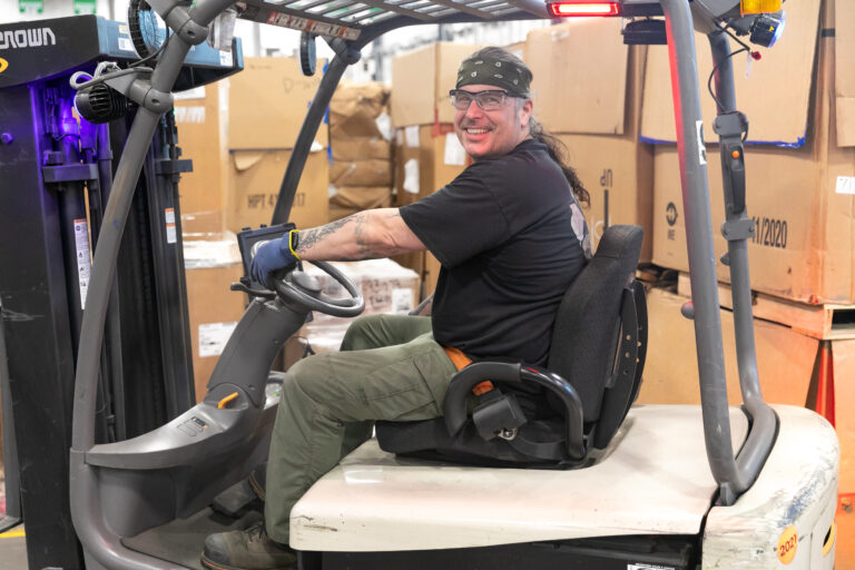 Dynamic Lifecycle Innovations employee operating a forklift in the materials recycling facility.