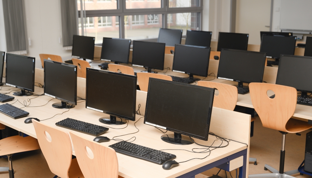 Computer monitors in a college classroom.