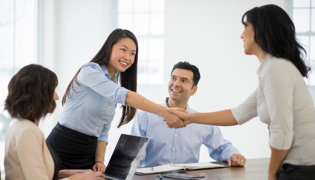 Women shaking hands with each other at an introduction meeting.