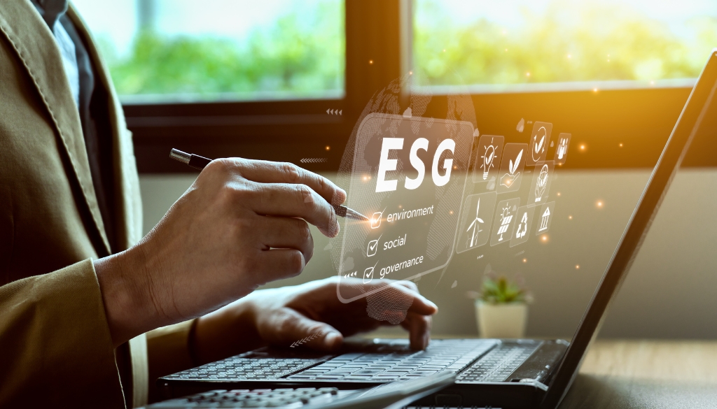 Environmental, Social, Global (ESG) icons floating above a man working on a laptop.