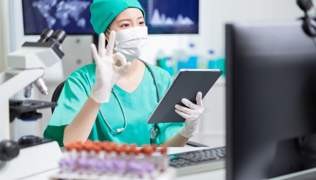 Doctor holding a tablet while completing a virtual consultation with a patient.