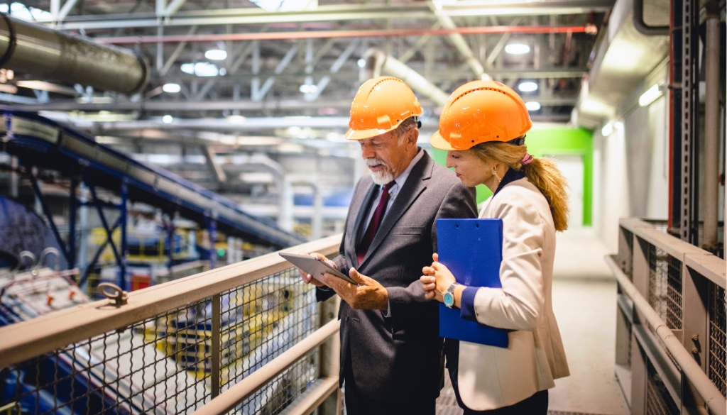 Business partners discussing an ITAD portfolio in an electronics recycling facility.