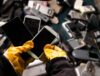 Unwanted IT Assets including mobile and landline phones being sorted by an electronics recycling professional.