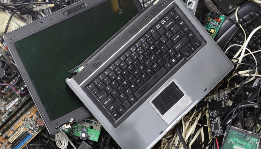 Laptop scrap in a pile of electronics waste.