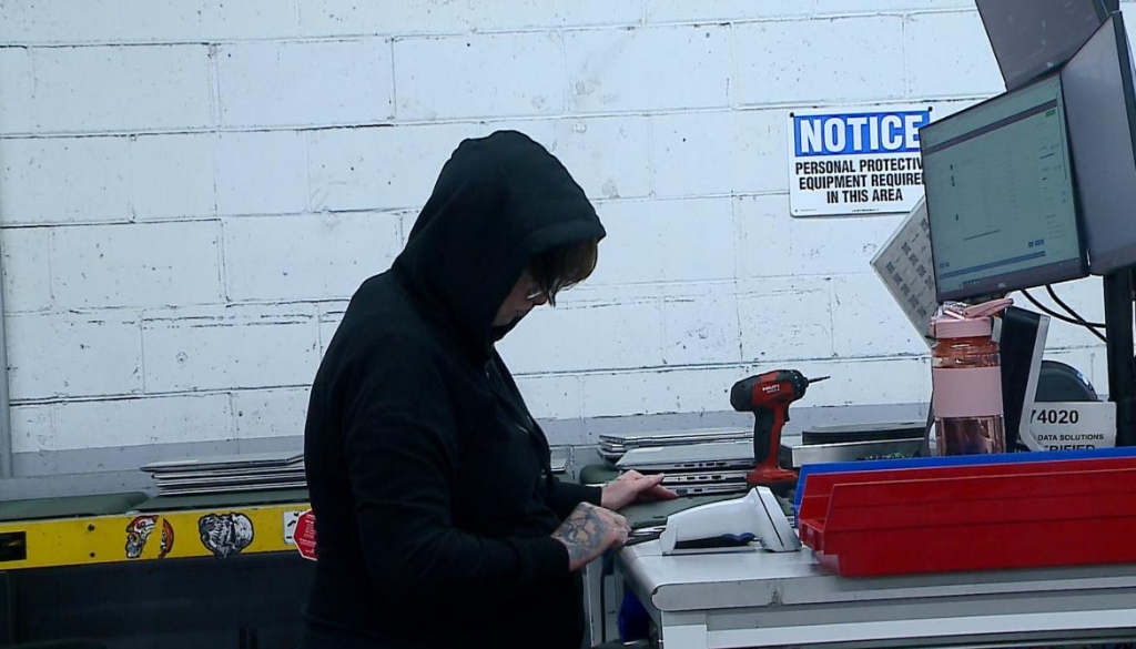 A female Dynamic Lifecycle Innovations employee working on recycled devices.