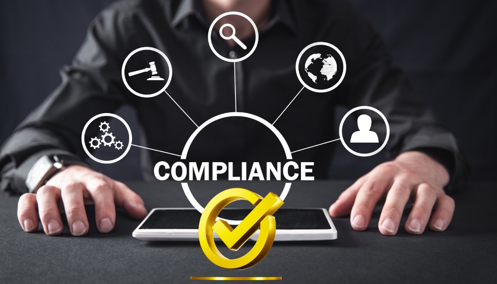 Compliance and certification icons coming out of a laptop with a man in the suit in the background.