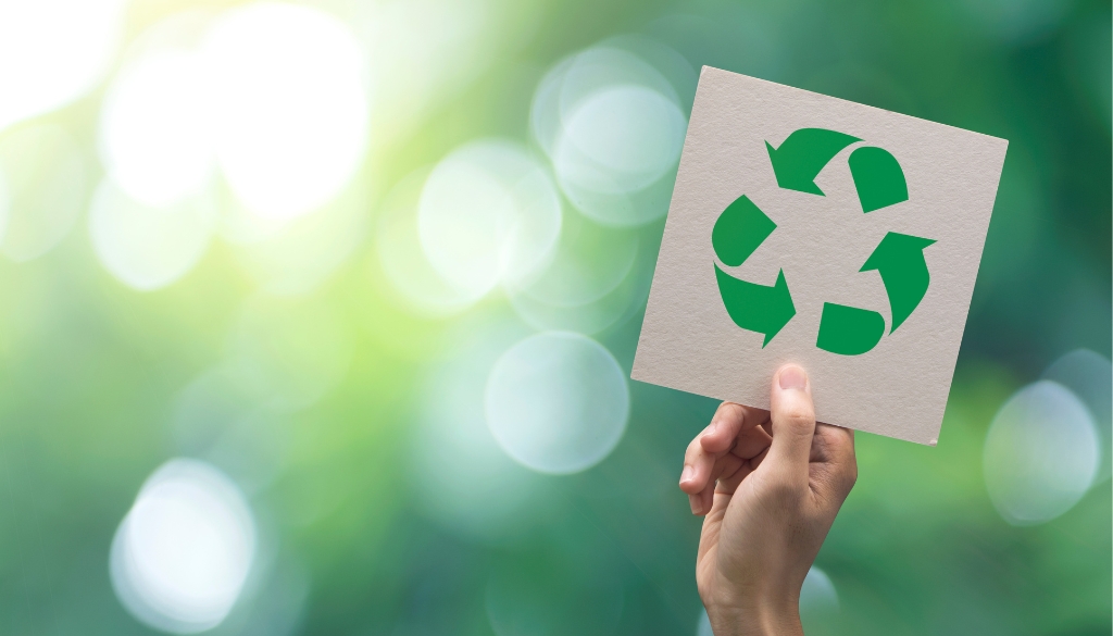 Person holding up the recycling symbol.