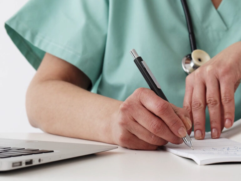 Healthcare provider filling out a prescription.