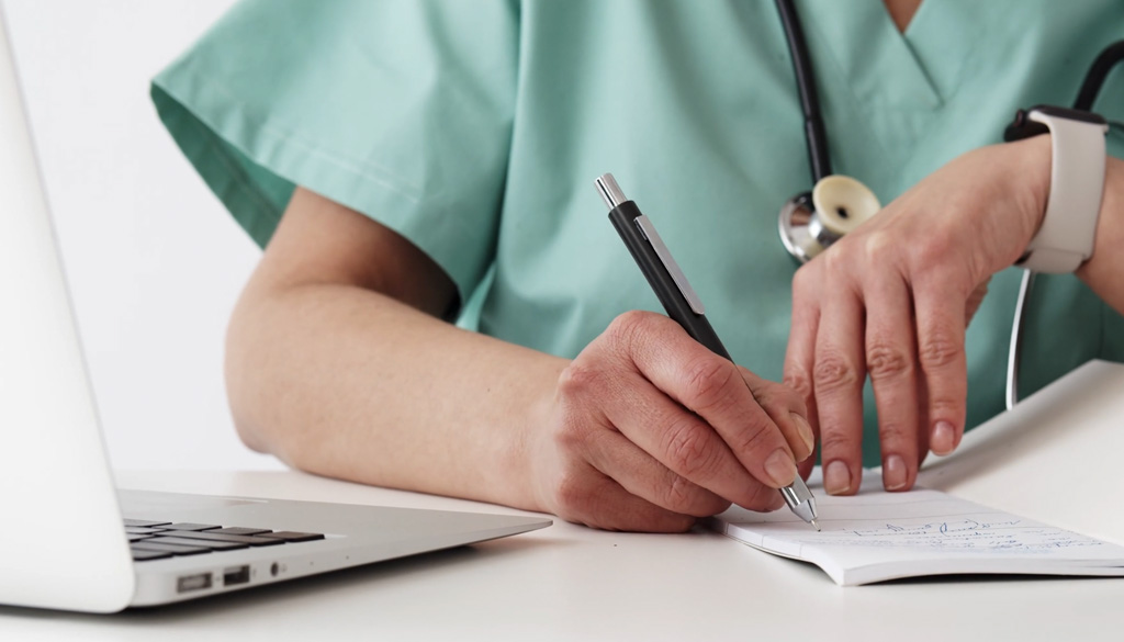 Healthcare provider filling out a prescription.