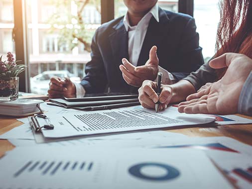 People looking at clipboards with graphs and charts during a business meeting.