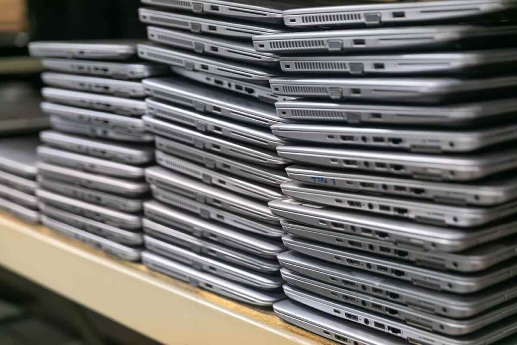 Stacks of decommissioned laptops awaiting recycling.